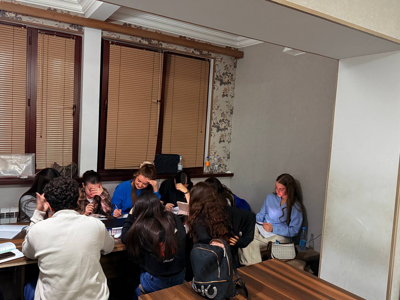 Students solving SAT and TOEFL questions together at a big table